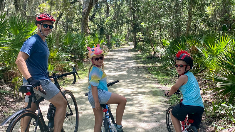 Family biking through Jekyll Island forest
